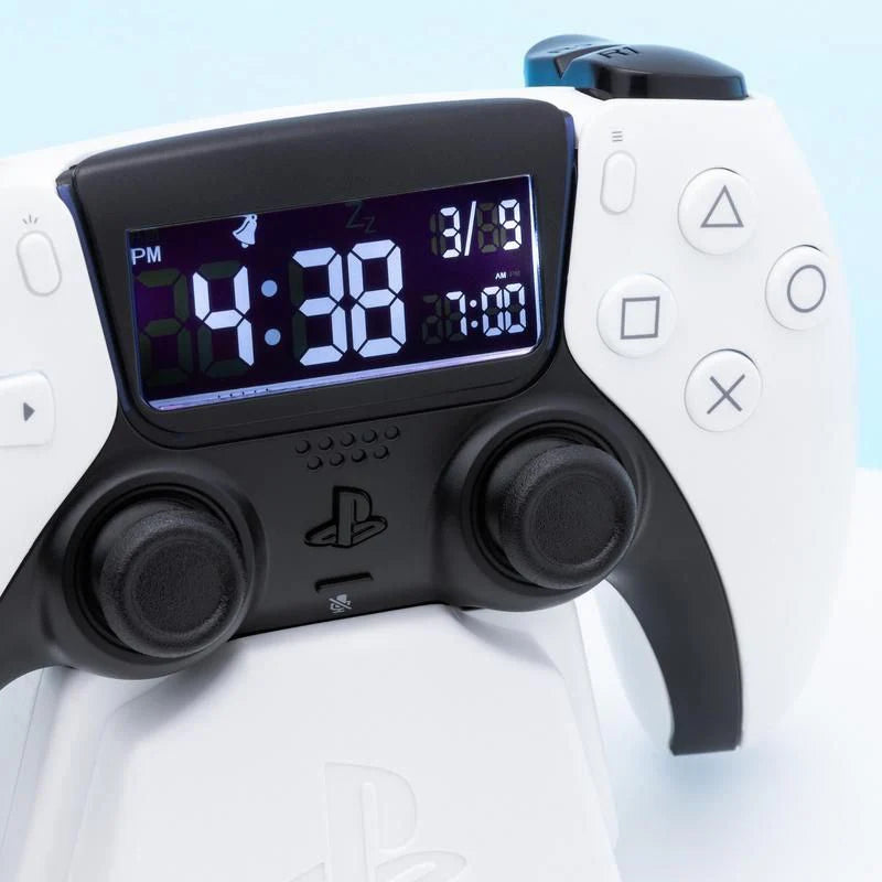 The Paladone Playstation 5 Controller Alarm Clock features a digital display on a white PS5-style controller, showing the time (4:38 PM), date (1/9), and an alarm set for 7:00.