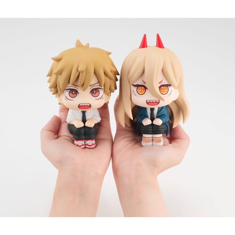 Two hands hold Bandai Namco’s Chainsaw Man Look Up Figure Denji & Power Limited Edition: Denji has messy brown hair, Power has long blonde hair with red horns. Both wear dark outfits and have expressive open-mouthed faces.