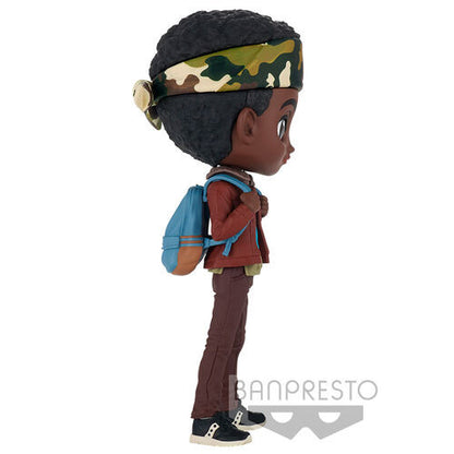 A side view of the Banpresto Lucas Q Posket Stranger Things vinyl figure by Bandai Namco features Lucas with dark skin, afro, camo headband, blue backpack, red jacket, brown pants, and black sneakers. The Banpresto logo is at the bottom.