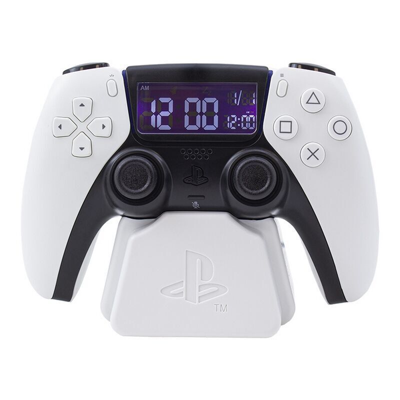The Playstation 5 Controller Alarm Clock by Paladone features a white PS5 DualSense controller design with a digital clock display showing white numbers on a blue background, resembling an alarm clock. Brand: Paladone.