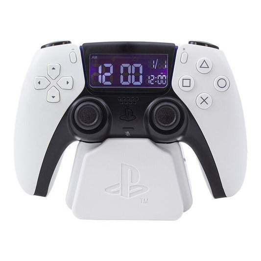 The Playstation 5 Controller Alarm Clock by Paladone features a white PS5 DualSense controller design with a digital clock display showing white numbers on a blue background, resembling an alarm clock. Brand: Paladone.