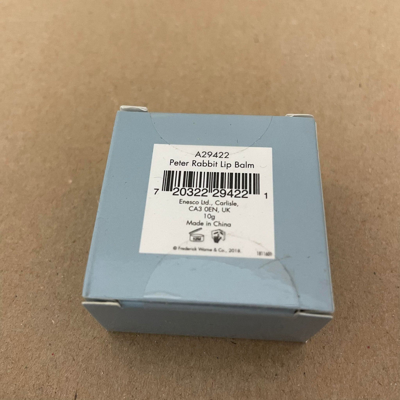 A small blue gift box from Beatrix Potter holds a Peter Rabbit Lip Balm Triple Pack, labeled with a barcode, noting it is made in China and weighs 10g.