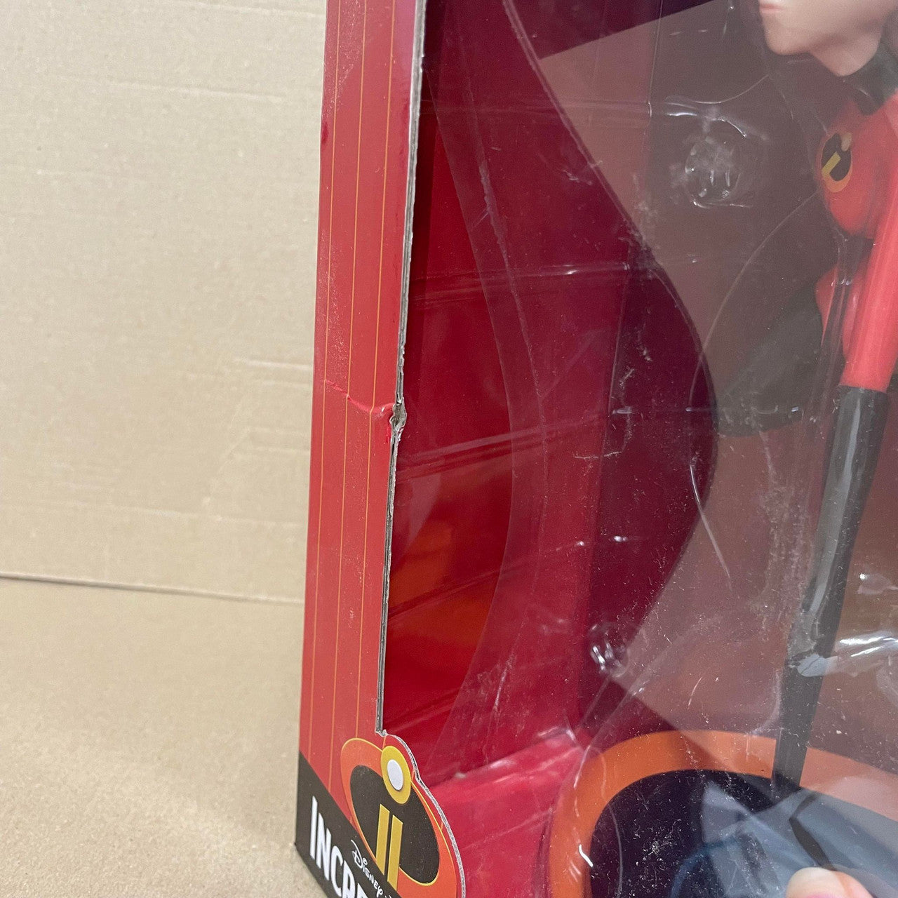 A Mrs Incredible Vinyl Figurine by Grand Jester Studios from Disney, in red packaging with a dent on the left side of the box. DAMAGED BOX noted. Incredibles logo at the bottom.