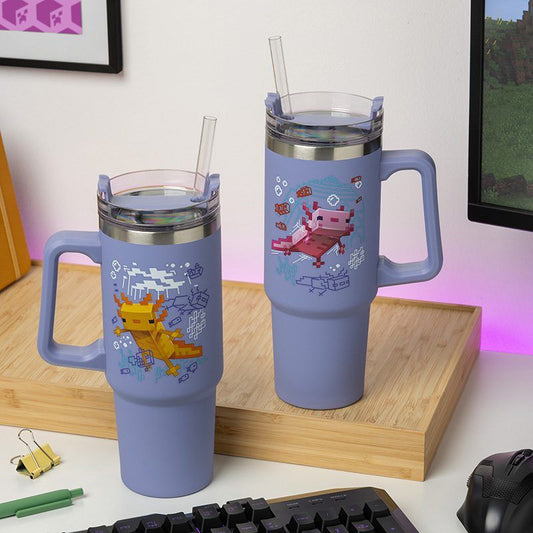 Two large purple Minecraft Insulated Cups with straws and handles by Paladone feature pixel art axolotl designs. Shown on a wooden tray near office supplies, theyre perfect for any Minecraft gamer’s collection.