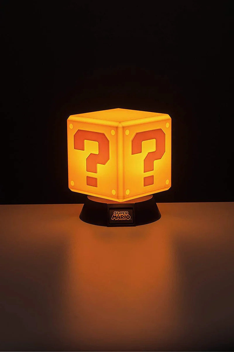 The Super Mario Bros. Question Block 3D Light by Paladone features a glowing yellow design on a black base, casting warm light—perfect for retro gaming fans and collectors.
