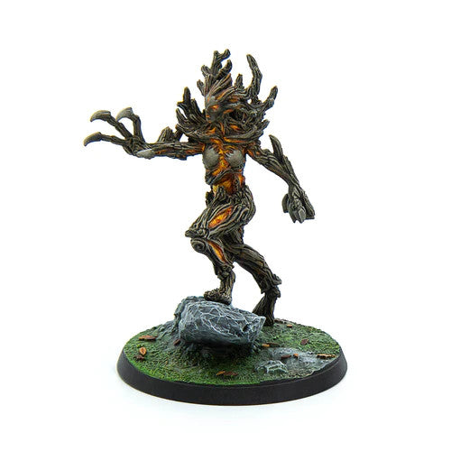 The Elder Scrolls Call To Arms Spriggan Matriarch by Modiphius is a painted miniature featuring the wooden, branch-like creature posed on one leg atop a grassy, rocky base, with an outstretched arm and orange energy highlights.